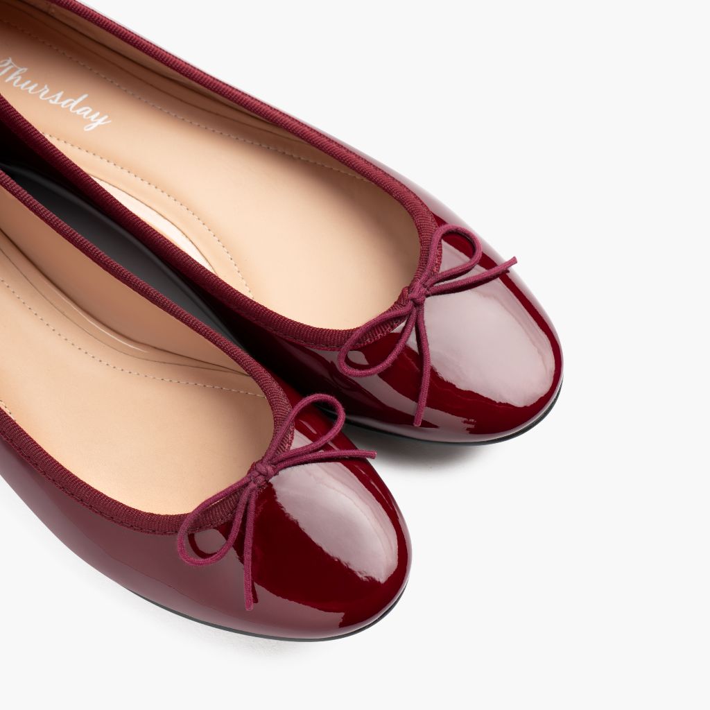 https://cdn.shopify.com/s/files/1/0419/1525/files/1024x1024-Wmn-TinyDancer-BurgundyPatent-020226-ToeDetail_c285d749-0272-4c88-a469-356de1f47dee.jpg?v=1773097337